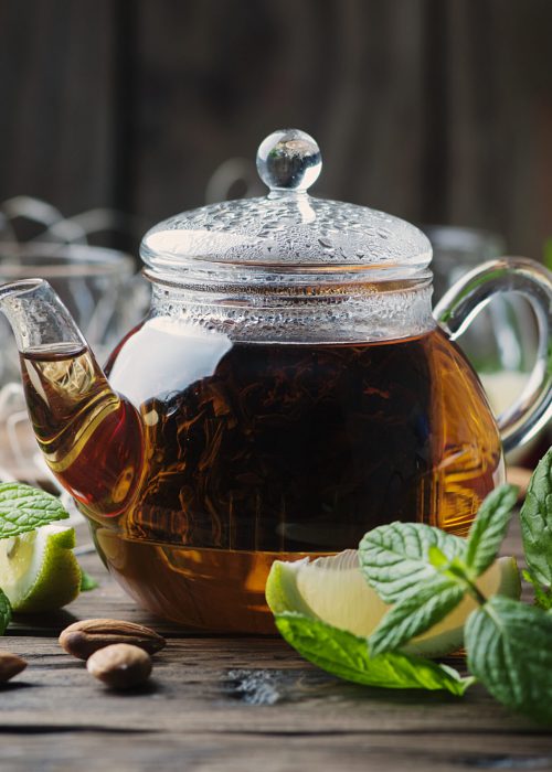 Hot black tea with lemon and mint on the wooden table